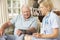 Retired Senior Man Having Health Check With Nurse At Home