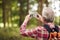 Retired Senior Man Hiking In Woodland Countryside Taking Photo With Mobile Phone