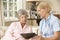 Retired Senior Woman Having Health Check With Nurse At Home