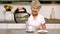 Retired woman pouring boiling water from kettle into cup in kitchen