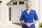 Retired woman standing outside house