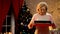 Retiree lady holding cooking dish with traditional biscuits, Xmas tree sparkling