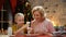 Retiree lady looking how excited girl decorates Xmas biscuits, happy Xmas time