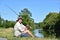 Retiree Male Fisherman Relaxing With Fishing Rod Outdoors