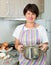 Retiree woman cooking soup