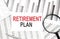 RETIREMENT PLAN text on paper with calculator,magnifier ,pen on graph background