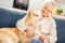 Retirement. Senior woman sitting at home hugging siberian husky smiling happy close-up