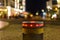 Retractable bollard with a red warning light as a barrier to a pedestrian area at night in Bansin, Germany. In the background you