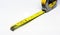 Retractable yellow metal measuring tape. Measurements expressed in centimeters and feet