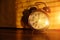 Retro alarm clock on table at eight clock in morning, illuminated by warm light rising sun