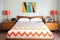 retro bedroom with chevron bedding, wooden nightstands, and graphic art