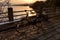 Retro bicycle, metal fence, stone floor, lake at sunset