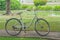 Retro bicycle standing on walkway with green grass background.