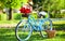 Retro bicycle with tulip flowers in basket. vintage bike in park. spring garden with green grass. nature full of colors