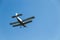 A retro biplane flying at high speed high in the air against a blue, cloudless sky