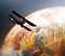 Retro biplane flying over spinning globe
