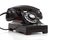 A retro black rotary phone on a white background