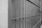 A retro black-and-white photograph of the steel cages of a prison cell.