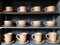 Retro Brown Clay Cups for Hot Coffee or Tea in Row on Shelf