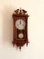 Retro brown old pendulum clock hanging on the wall