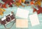 Retro camera and empty old instant paper photo album on wood table with maple leaves in autumn border design