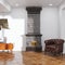 Retro ceramic fireplace in new white loft interior with mid century furniture and wooden parquet floor 3d render