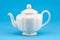 Retro ceramic white teapot dish on blue background