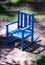 Retro child`s blue rocking chair in dappled sunlight