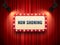 Retro cinema or theater frame illuminated by spotlight. Now showing sign on red curtain backdrop. Movie premiere signs