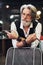 In retro clothes in barbershop. Stylish modern senior man with gray hair and beard is indoors