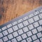 Retro effect computer keyboard on old vintage wooden table