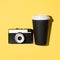 Retro film camera and disposable cup of coffee, close-up.