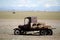 Retro flatbed truck with hay bales in a farm field.