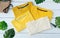 Retro fold Yellow cotton T-Shirt clothes colorful mock up template on grunge white wood background concept for retail dress shop