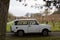 A retro german car is parked in front of some vineyards