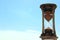 retro hourglass on the background of blue sky and white clouds