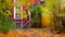 Retro house entrance porch and maples in autumn