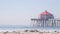 Retro huntington pier, surfing in ocean waves and beach, California coast, USA.