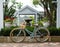 Retro ladies bicycle with basket standing against garden retaining brick wall with lush green shrubs in background