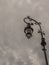 A retro lampost at a dark sky with clouds