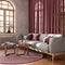 Retro living room with curtains, fabric sofa and rattan carpet in red and beige tones. Parquet floor and arched window. Farmhouse