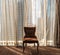 Retro looking Executive armchair against sheer curtains