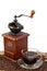 Retro manual coffee mill on roasted coffee beans with a cup of coffee