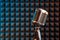 Retro microphone on acoustic foam panel background,