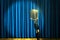 Retro microphone on stage over blue curtains