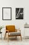 Retro and minimalist compositon of living room interior with design armchair, mock up poster map, lamp, decoration, white wall.