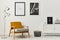 Retro and minimalist compositon of living room interior with design armchair, two mock up poster map, lamp, decoration, white wall