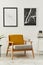 Retro and minimalist compositon of living room interior with design armchair, two mock up poster map, lamp, decoration, white wall