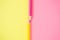 Retro optimistic vibrant bold colors meet in half of paper with yellow an pink wooden crayons. Minimal copy space design.