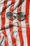 Retro pair of sunglasses on red and white striped beach towel